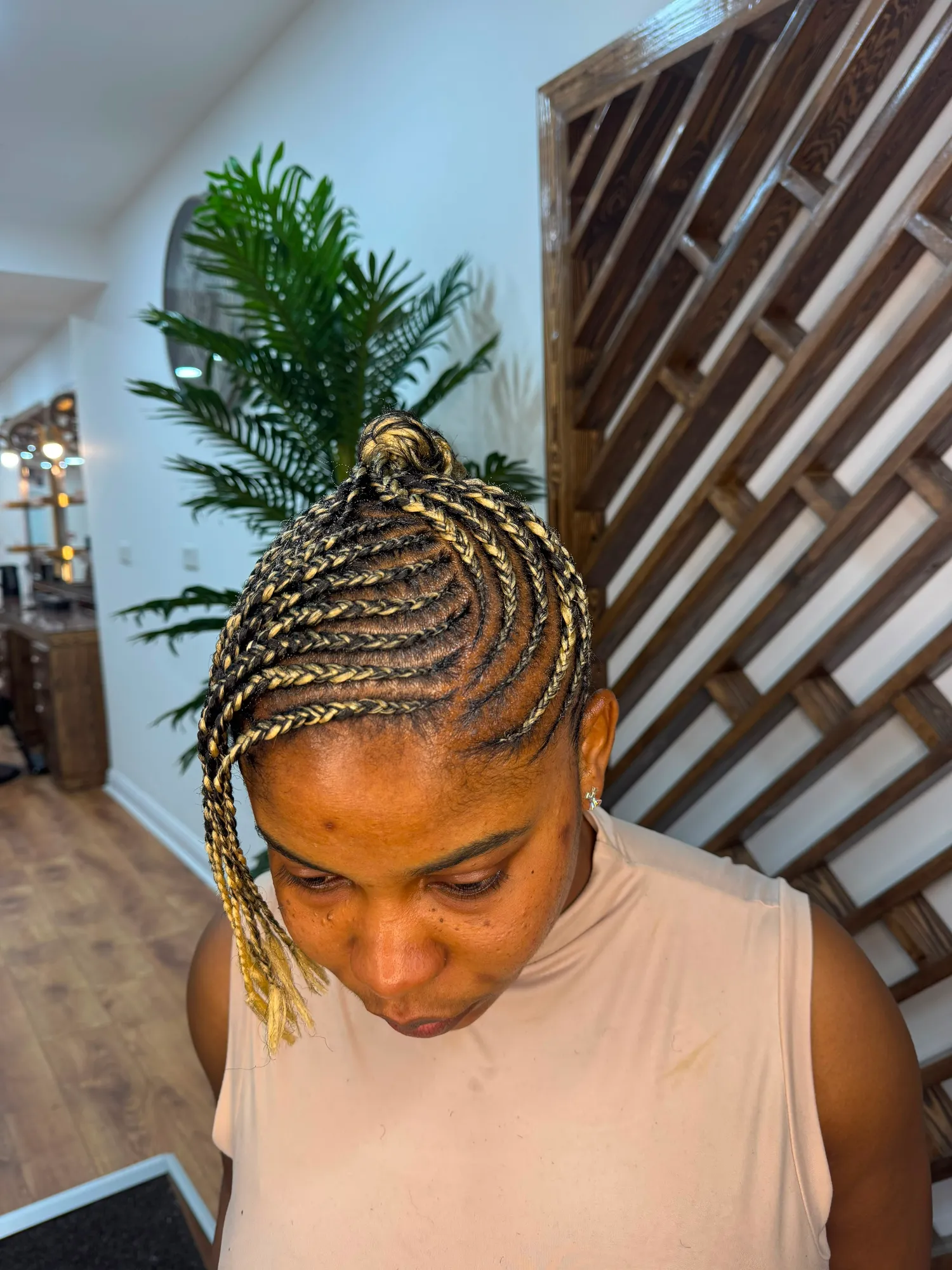 Blonde feed-in cornrows into a top knot